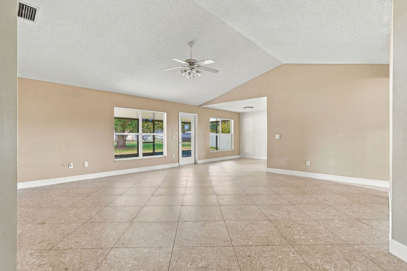 Great room with vaulted ceilings, ceiling fan, and tile floors at 707 Merrimac St SE