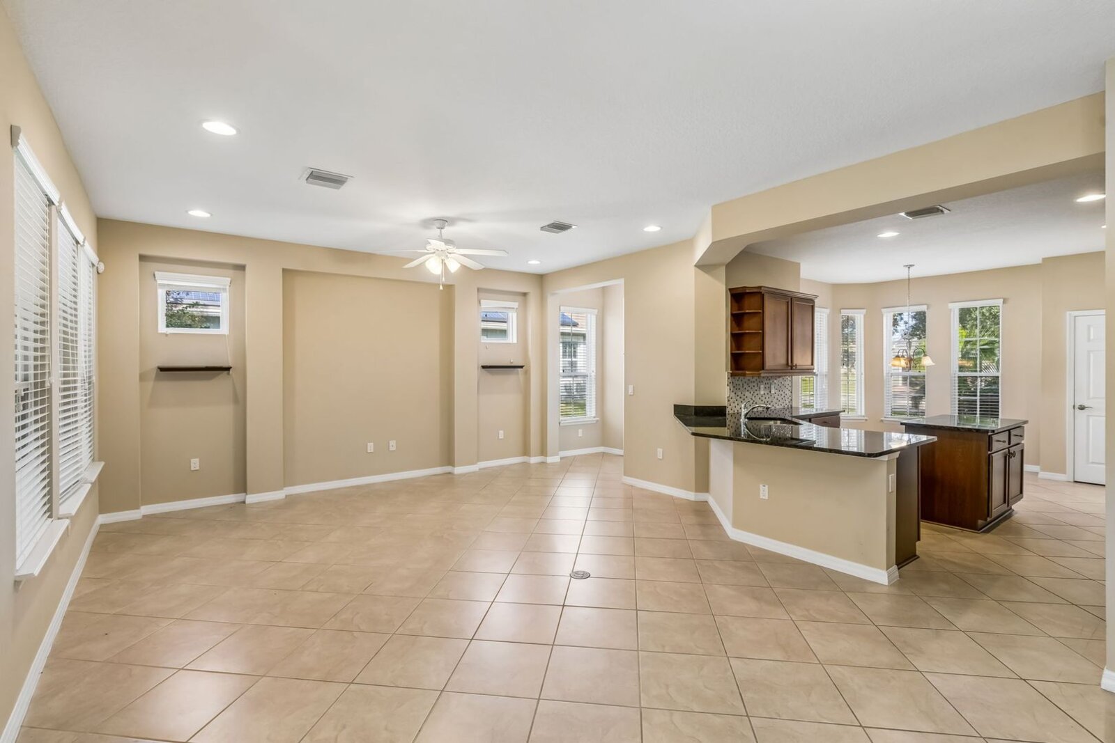 Open great room and kitchen with tall ceilings and diagonal tile at 374 Salt Marsh Ln