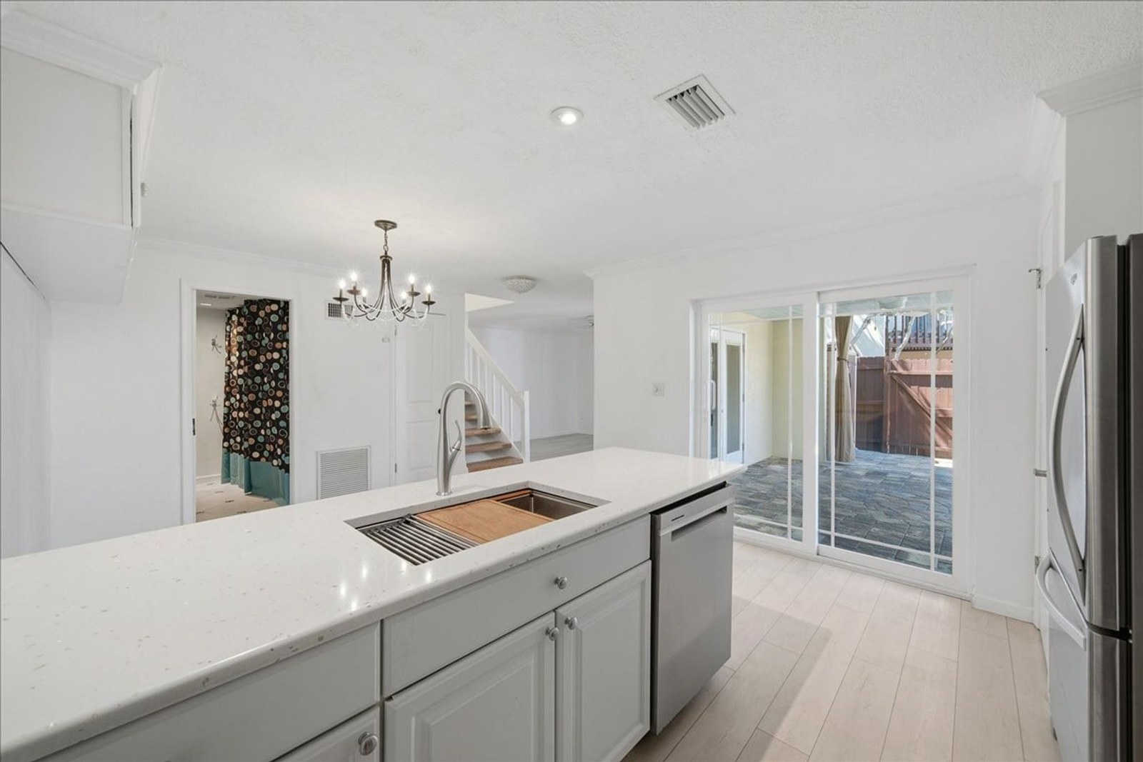 Kitchen peninsula with pendant lighting and hurricane-rated sliders to the private patio