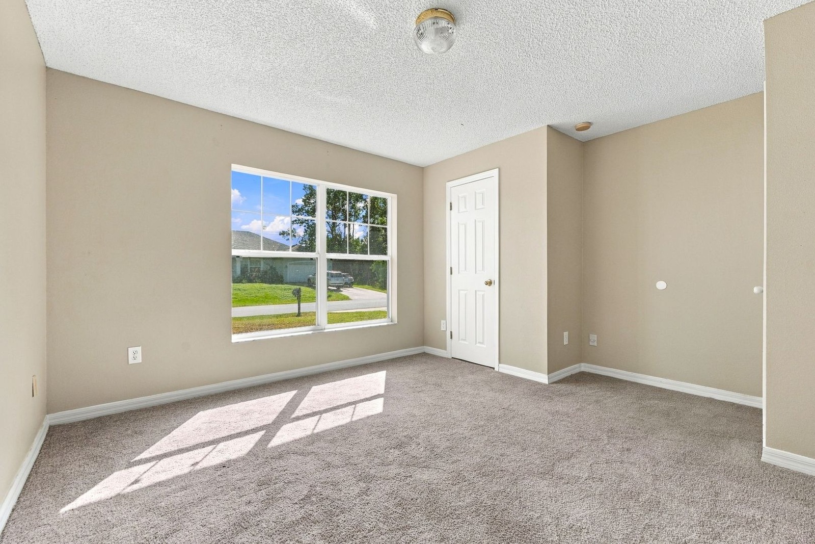 Second bedroom with carpet and window at 707 Merrimac St SE