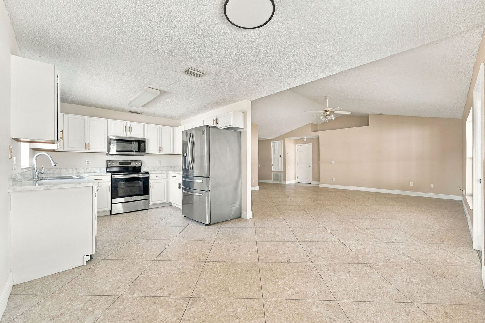 Kitchen with white cabinets opening to the great room at 707 Merrimac St SE
