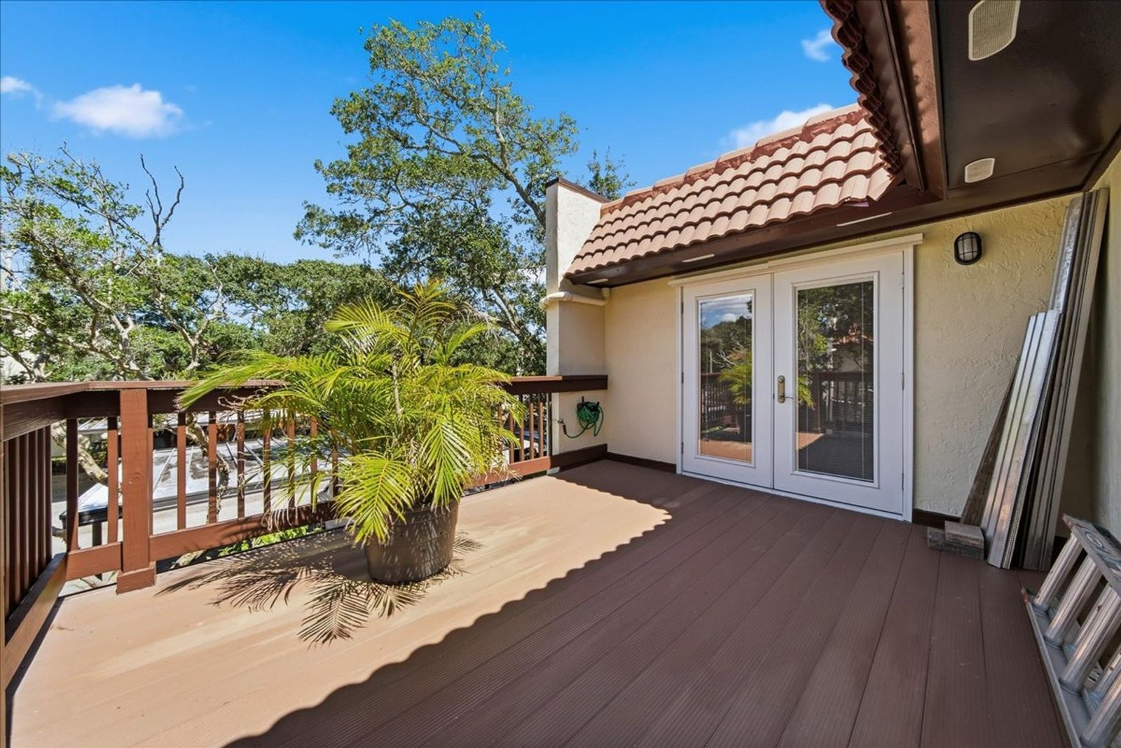 Upstairs balcony with French doors and Spanish-tile roofline