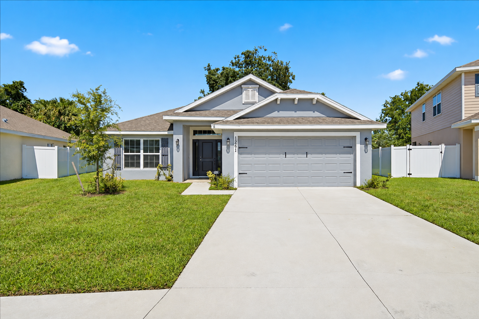 Front exterior of 1261 Tupelo Cir in Cocoa with two-car garage and extra-long driveway