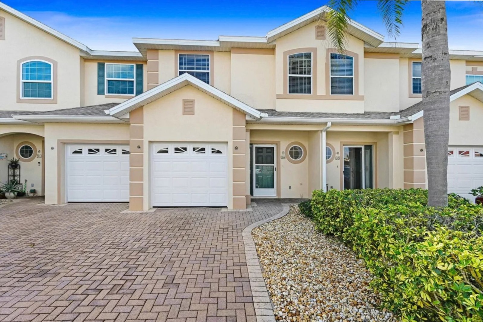 Front exterior of 5201 Ocean Beach Blvd #20 with paver driveway and attached garage