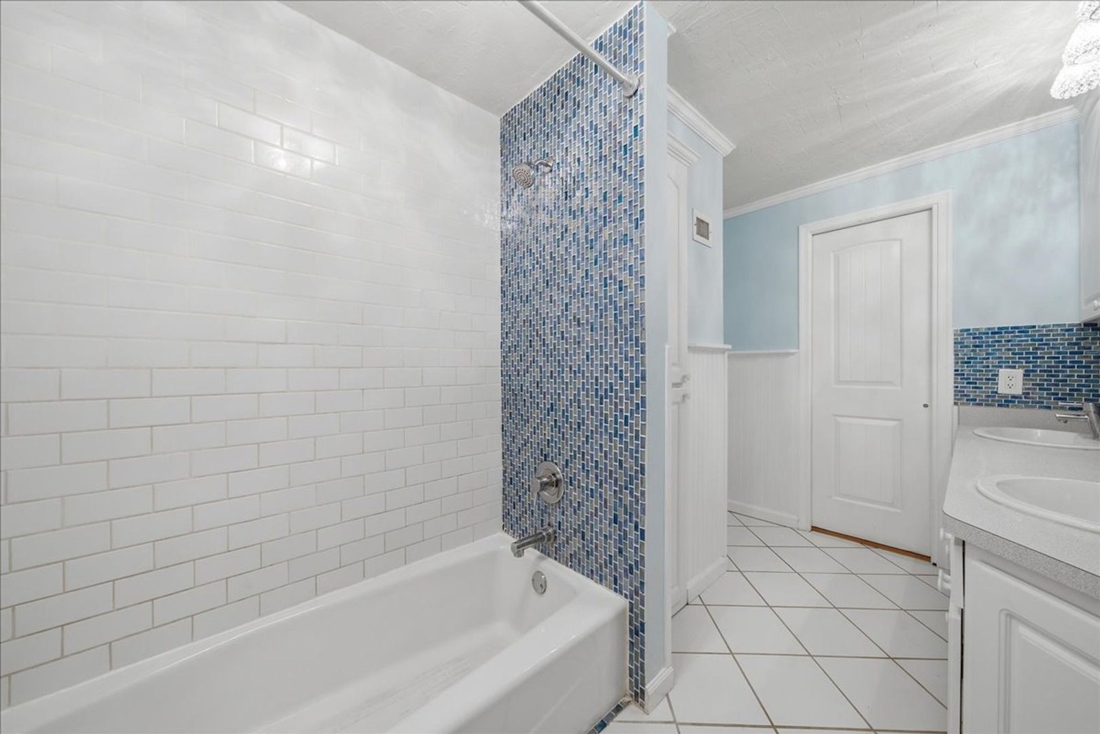 Bathroom with white subway tile and blue mosaic shower at 8760 Live Oak Ct
