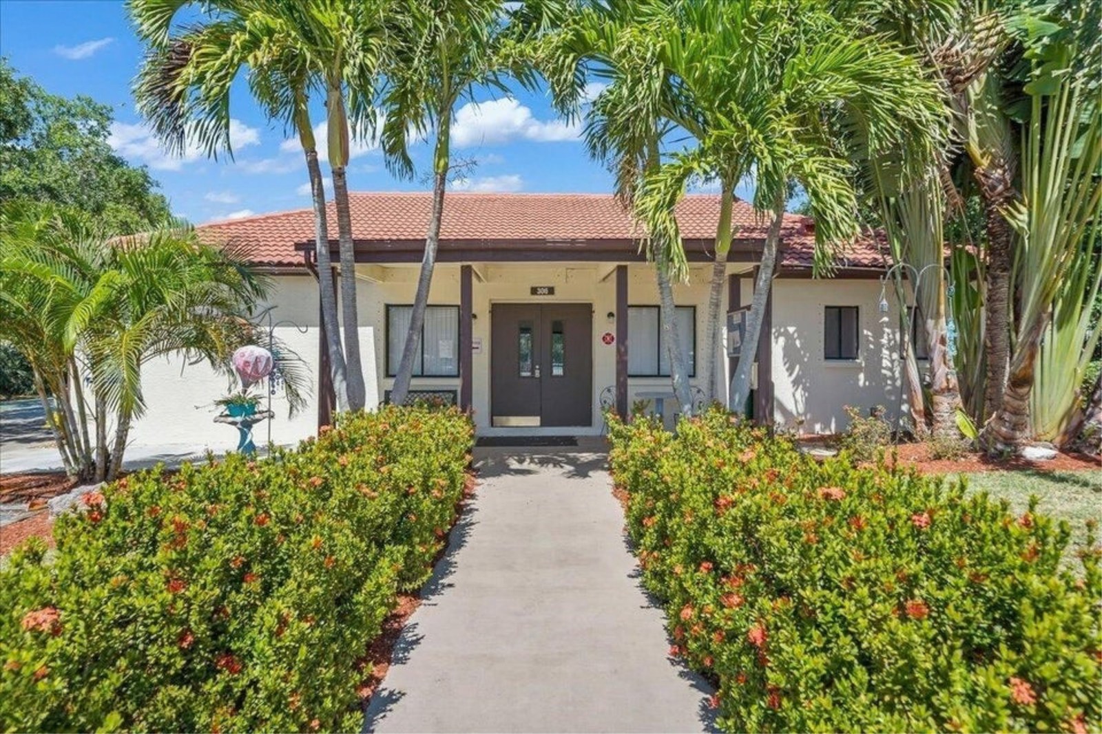 Ocean Woods townhome building with mature palms and tropical landscaping in Cape Canaveral