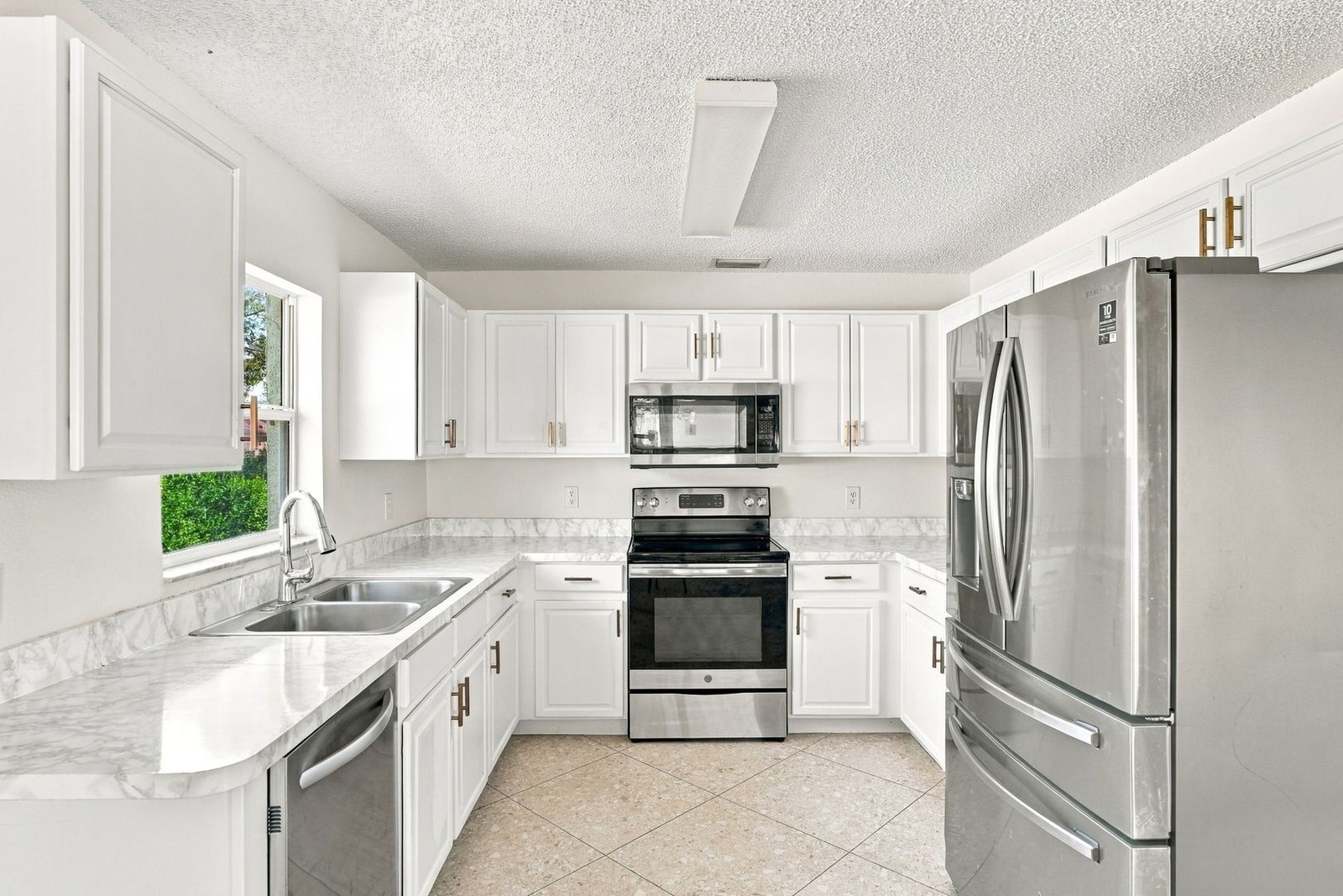 Kitchen with white cabinets, marble-look counters, and stainless appliances at 707 Merrimac St SE