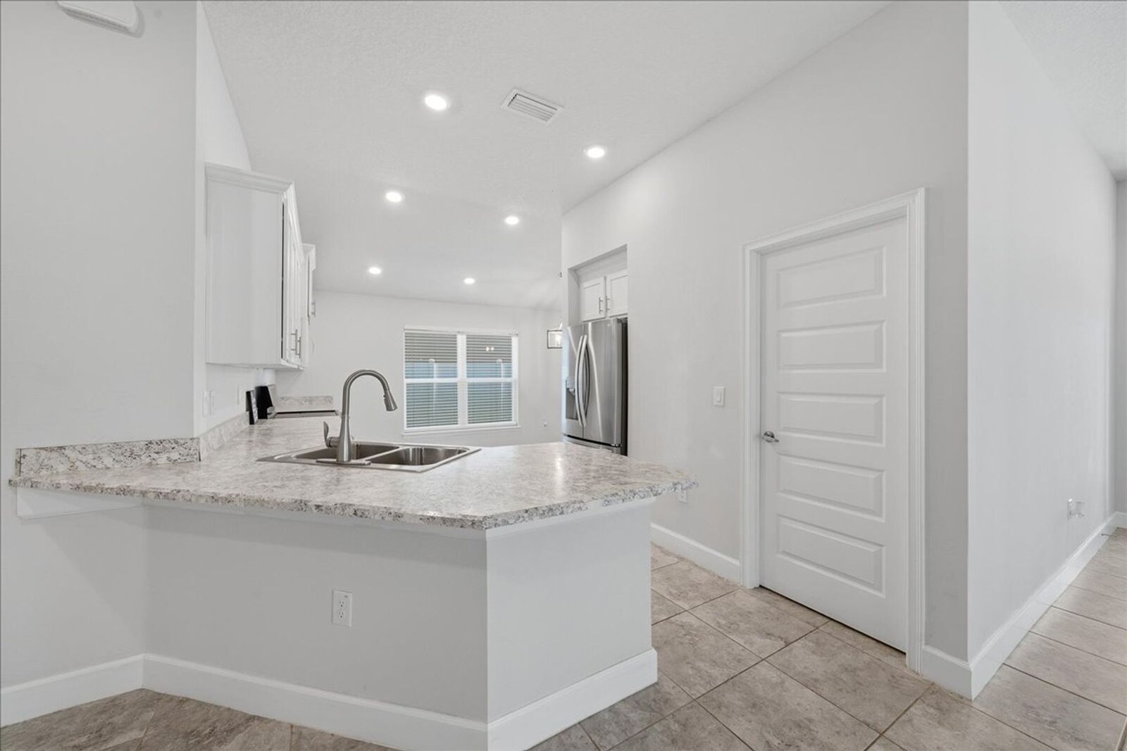 Breakfast bar and kitchen sink with granite-look counters at 1261 Tupelo Cir