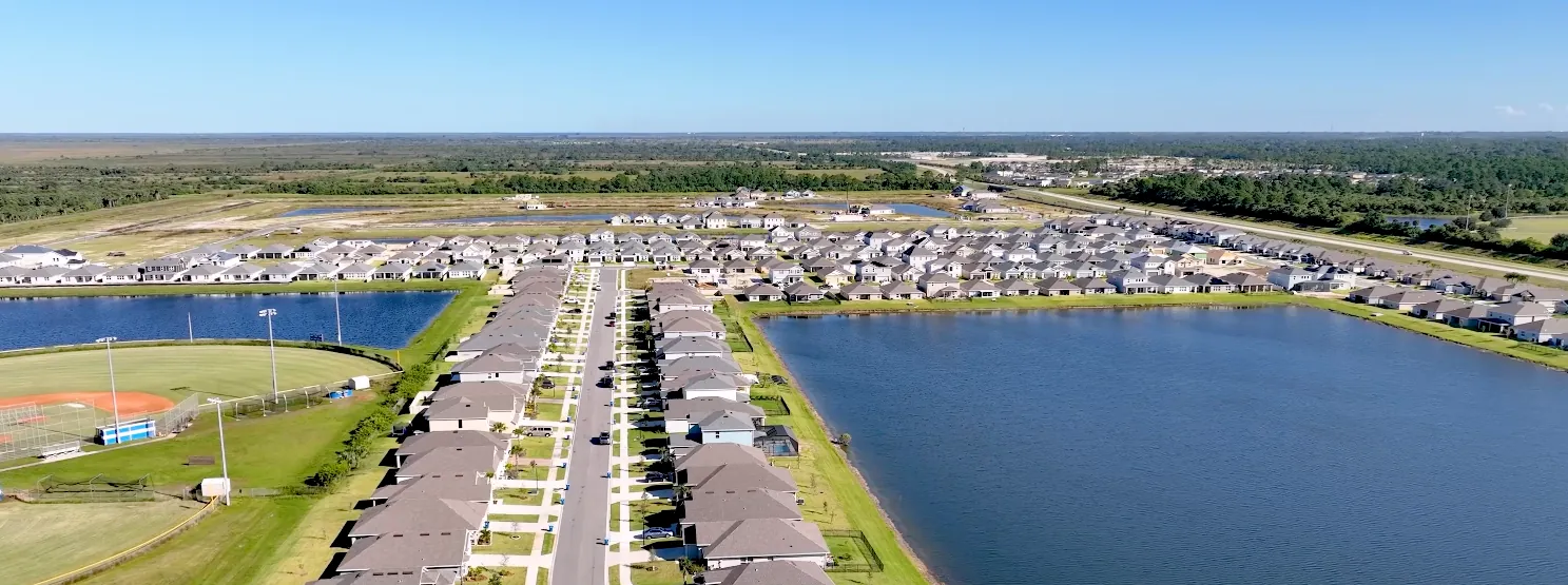 Aerial view of Palm Bay FL neighborhoods along Turkey Creek and the Indian River Lagoon, with new-construction streets beside lakes and ballfields
