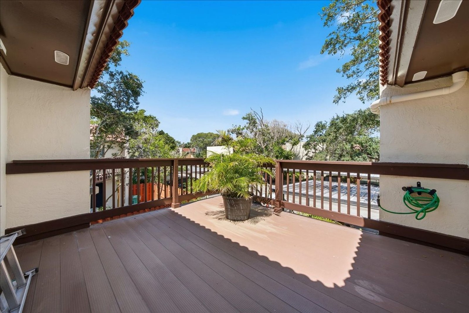 Spacious upstairs balcony with wood railings and treetop views at 8760 Live Oak Ct — a front-row seat for rocket launches