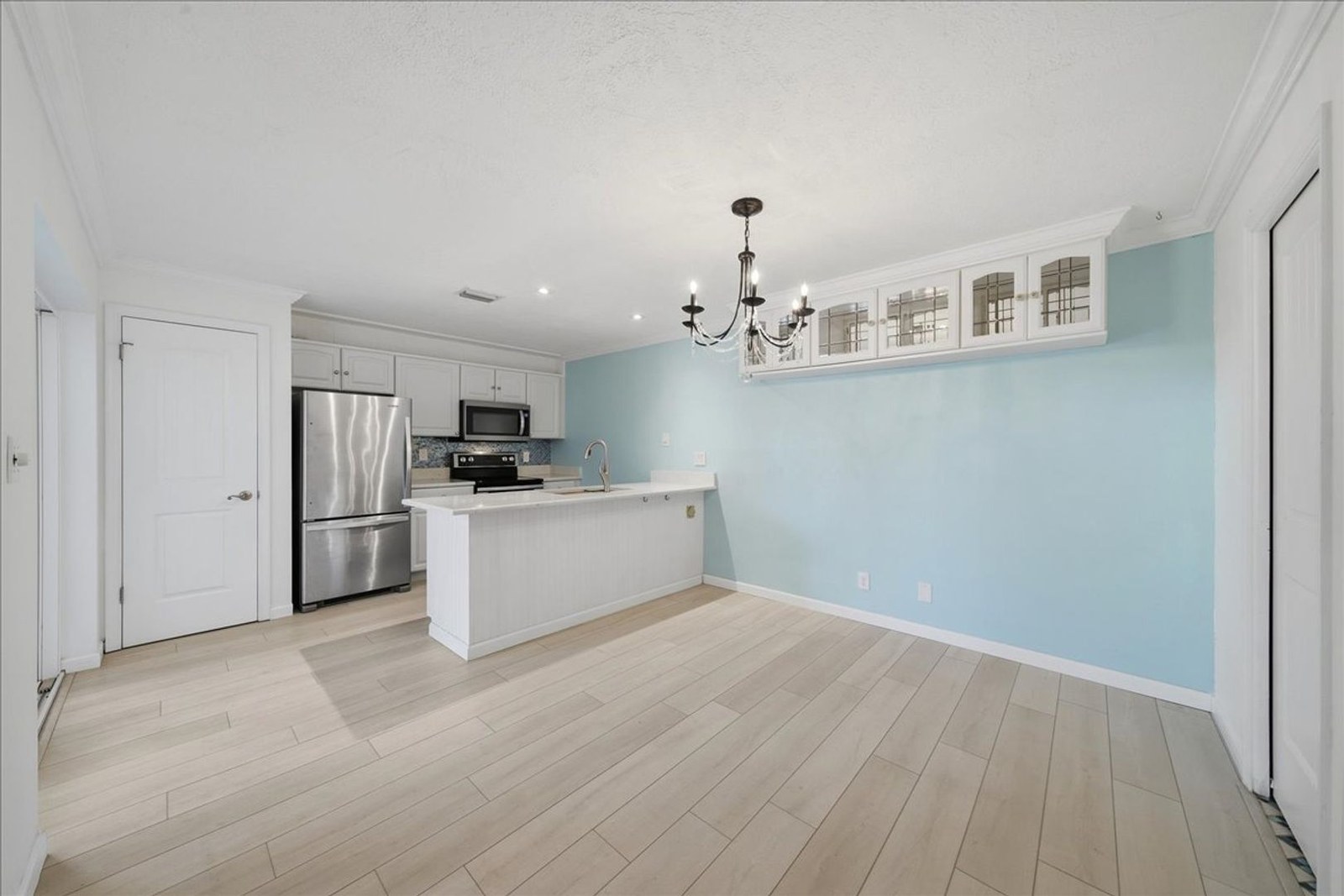 Kitchen and dining area with chandelier and light blue walls