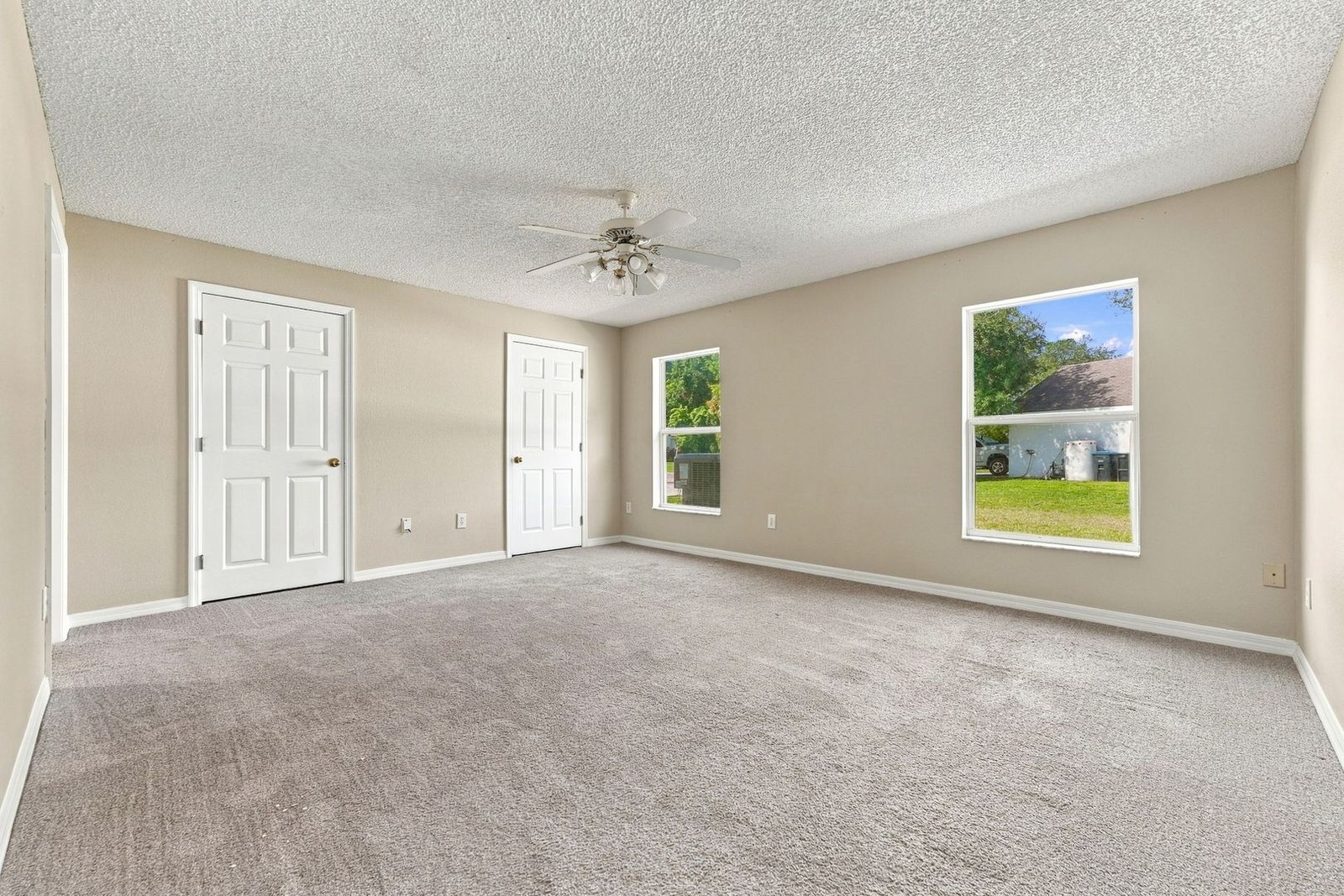Primary bedroom with ceiling fan and two windows at 707 Merrimac St SE