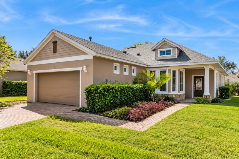 Front exterior of 374 Salt Marsh Ln in Trilogy Orlando with paver driveway and two-car garage