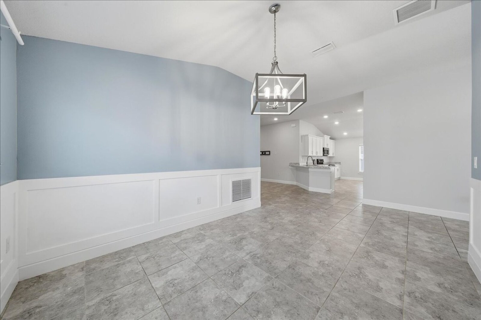 Formal dining room with wainscoting looking toward the kitchen at 1261 Tupelo Cir