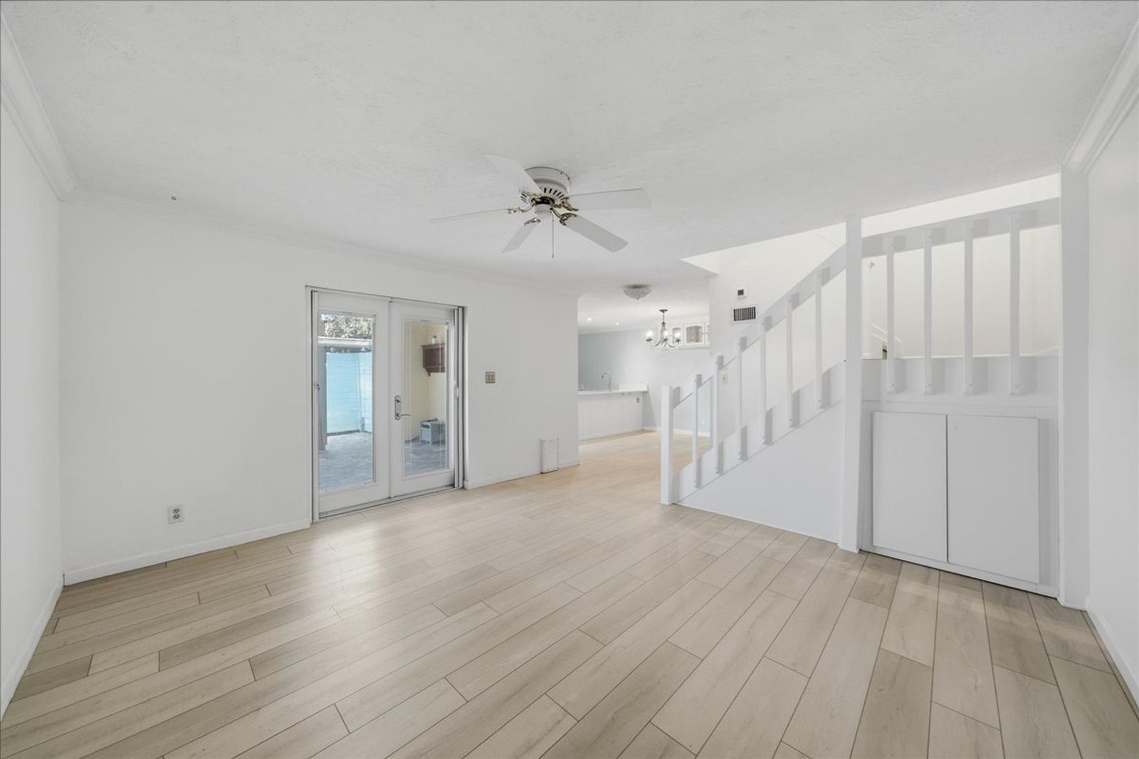 Bright living room with staircase and light wood-look floors at 8760 Live Oak Ct