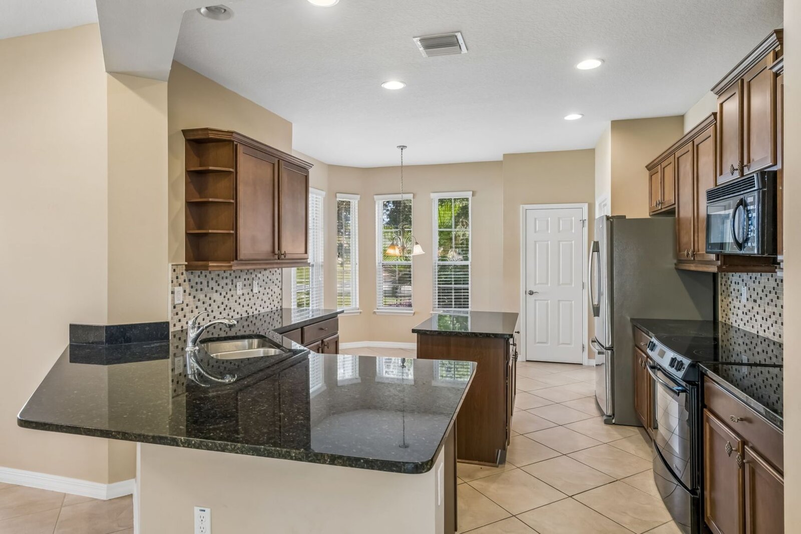 Kitchen breakfast bar and wood cabinetry at 374 Salt Marsh Ln
