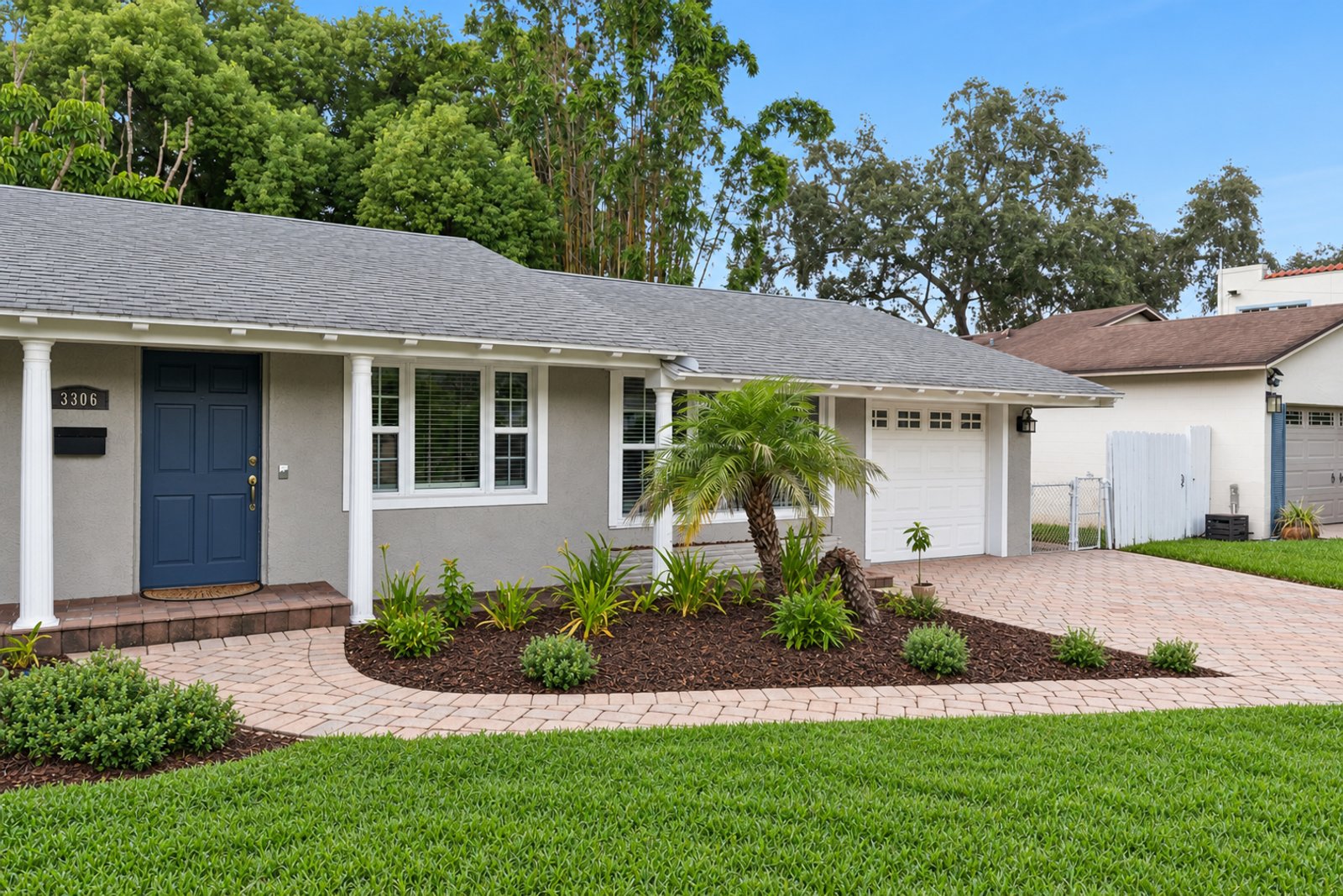 Front entry with navy door, paver walkway, and fresh landscaping at 3306 Eagle Blvd