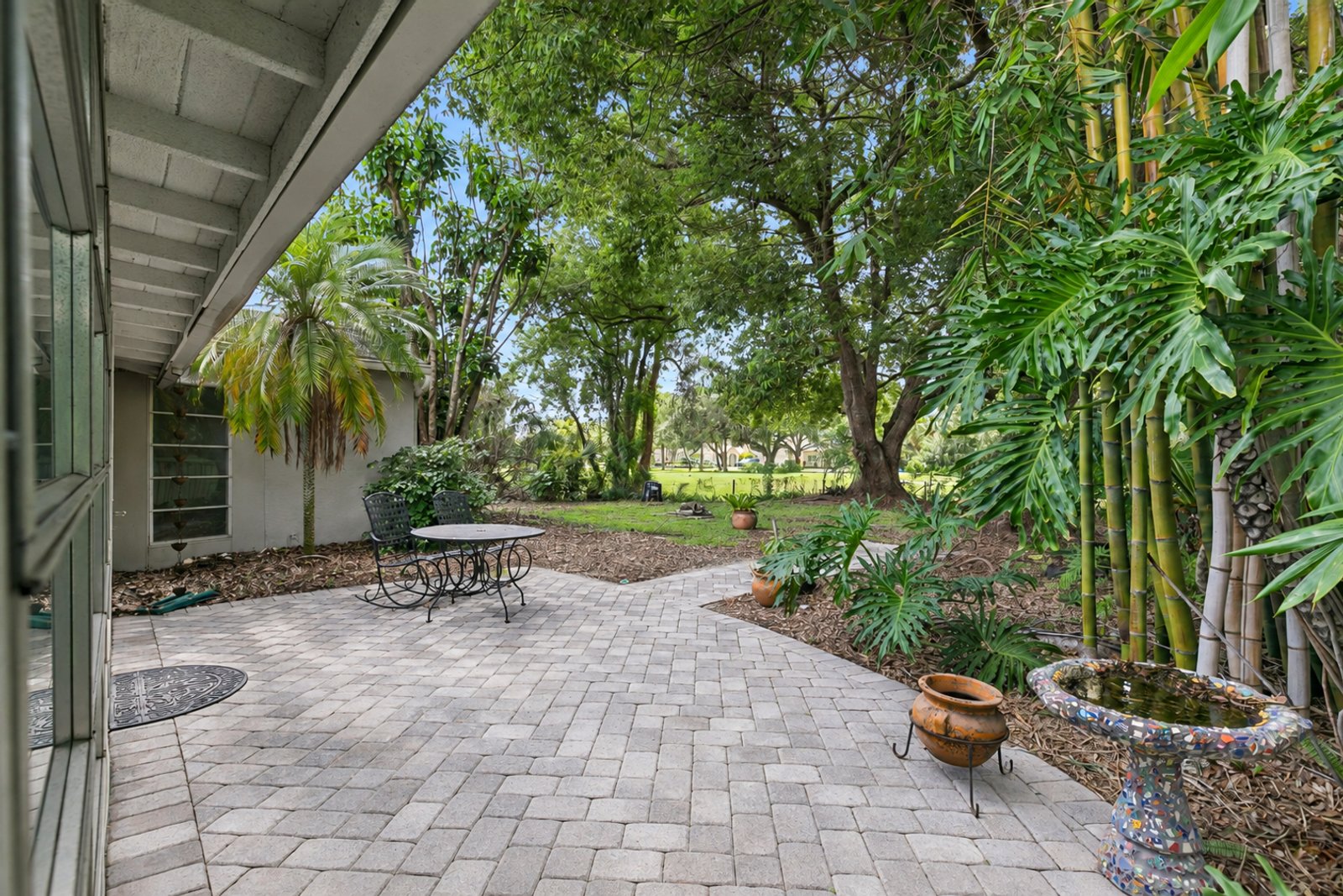 Paver patio and shaded backyard looking toward the golf course at 3306 Eagle Blvd