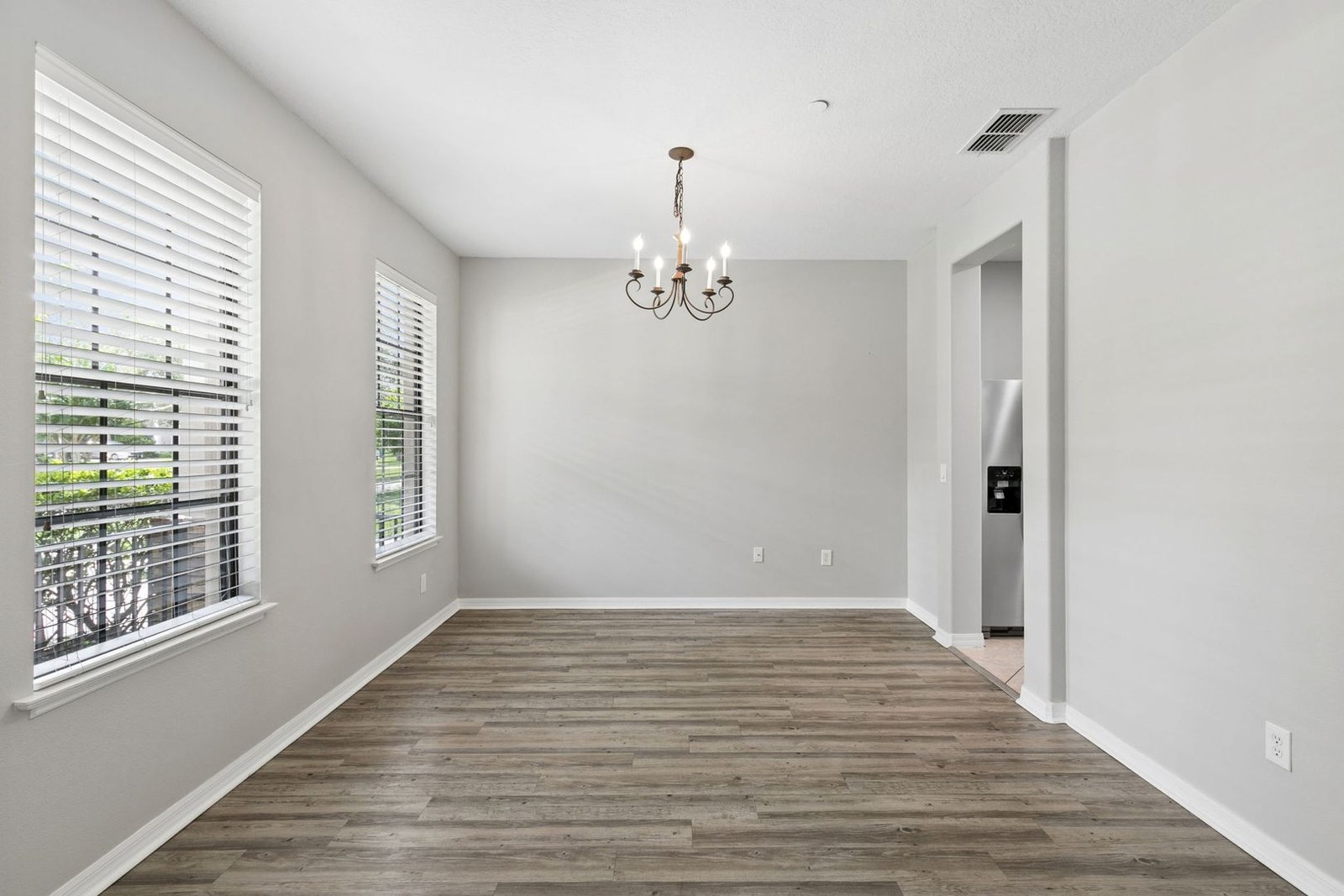 Flex room with plantation shutters and chandelier