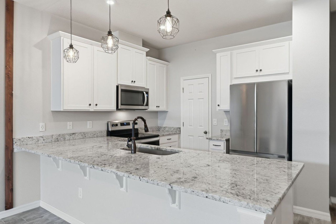 Granite island with bar seating and stainless appliances at 2946 Firebush Way