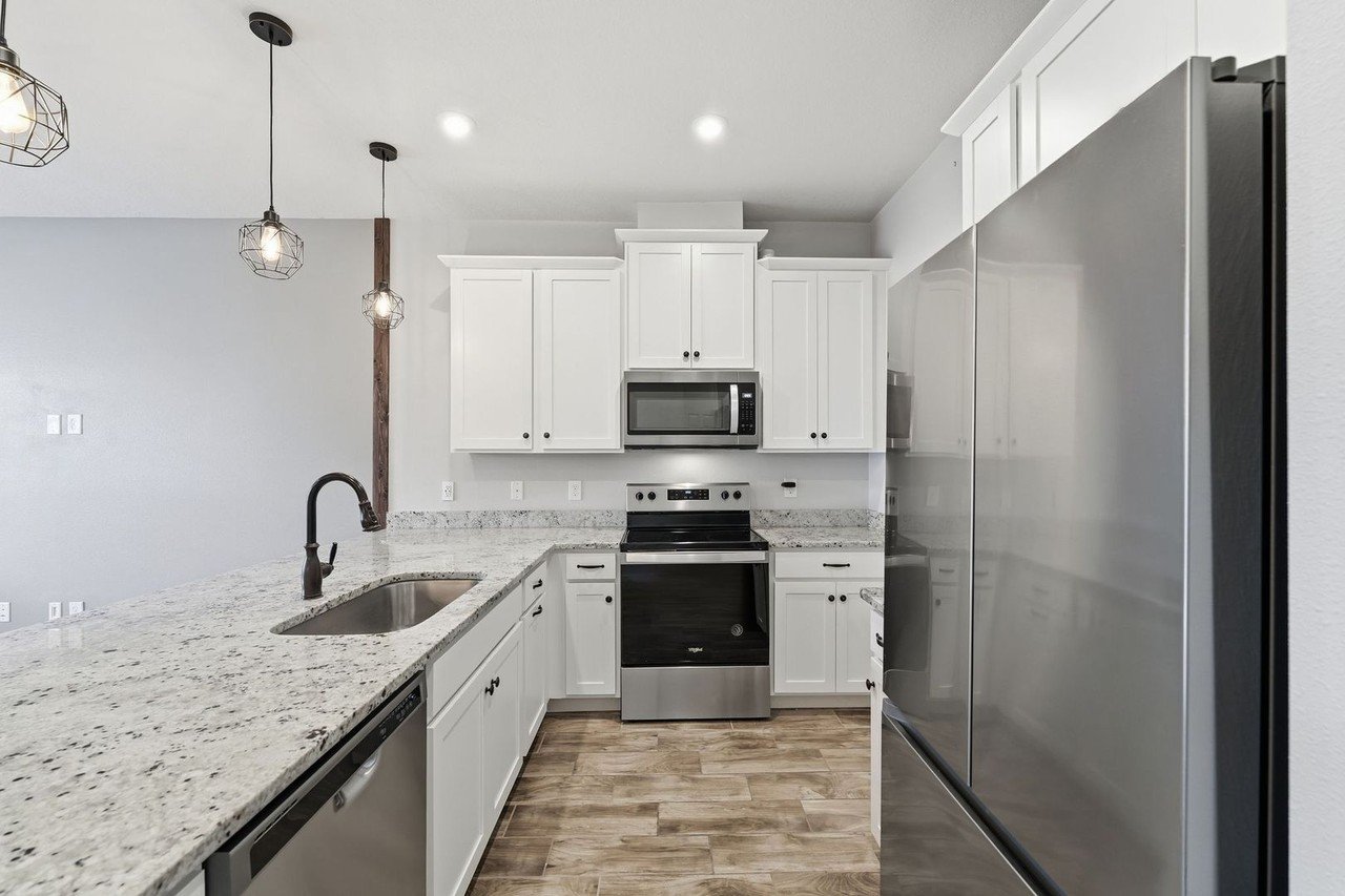 Kitchen with stainless steel range, microwave, and refrigerator