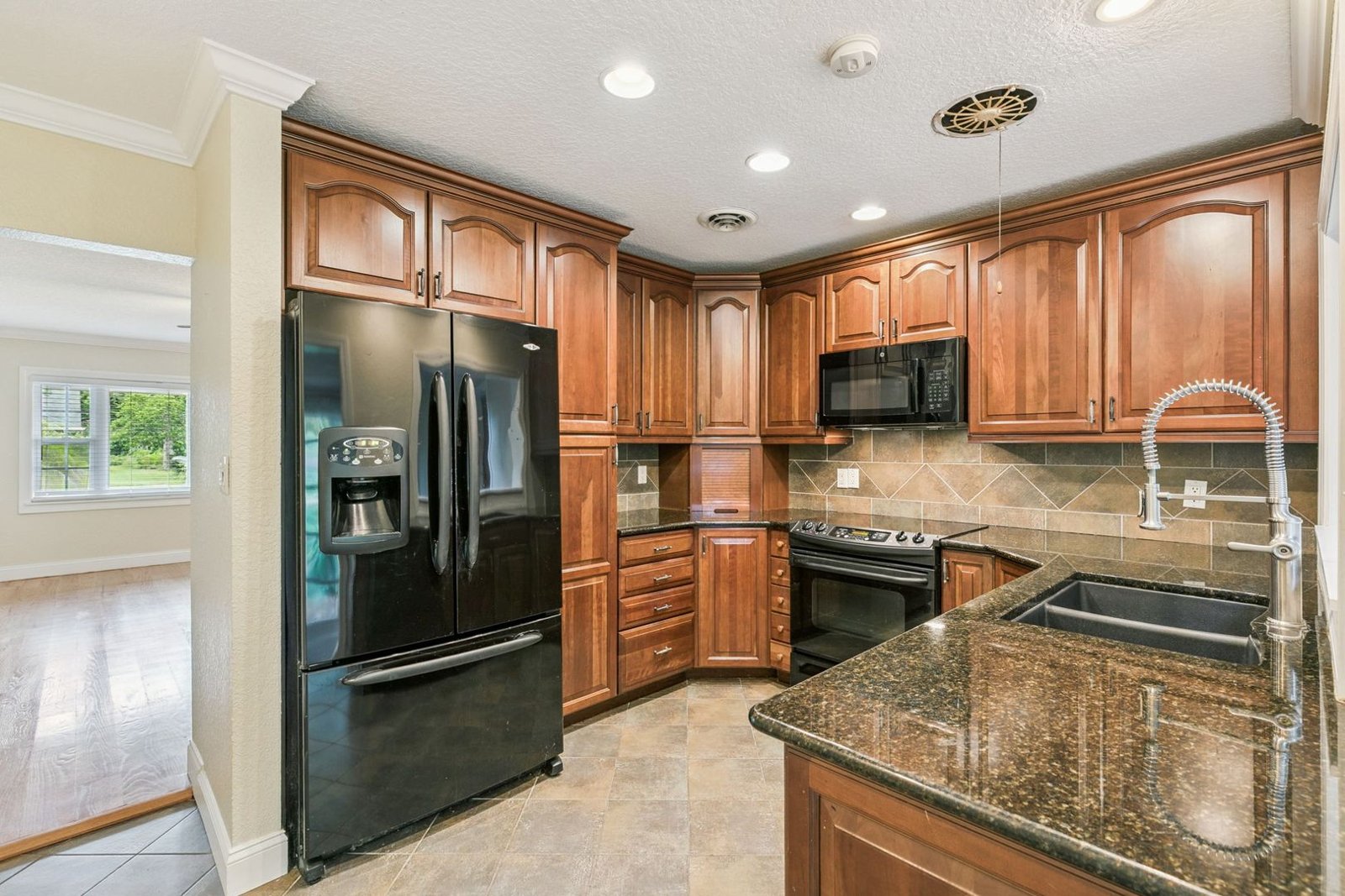 Kitchen with wood cabinetry, granite countertops, and French-door refrigerator at 3306 Eagle Blvd