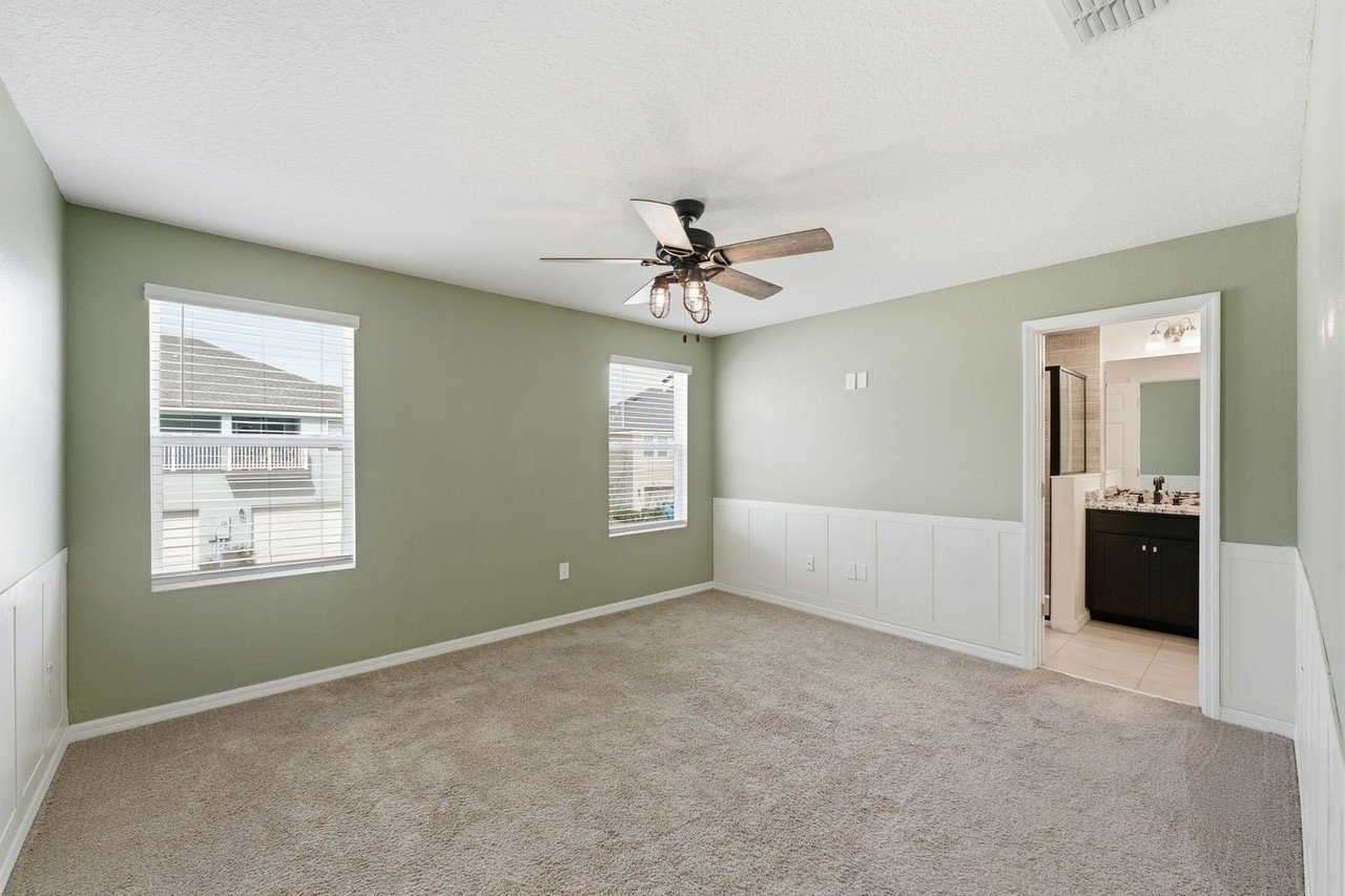Primary bedroom with ceiling fan and carpet at 2946 Firebush Way