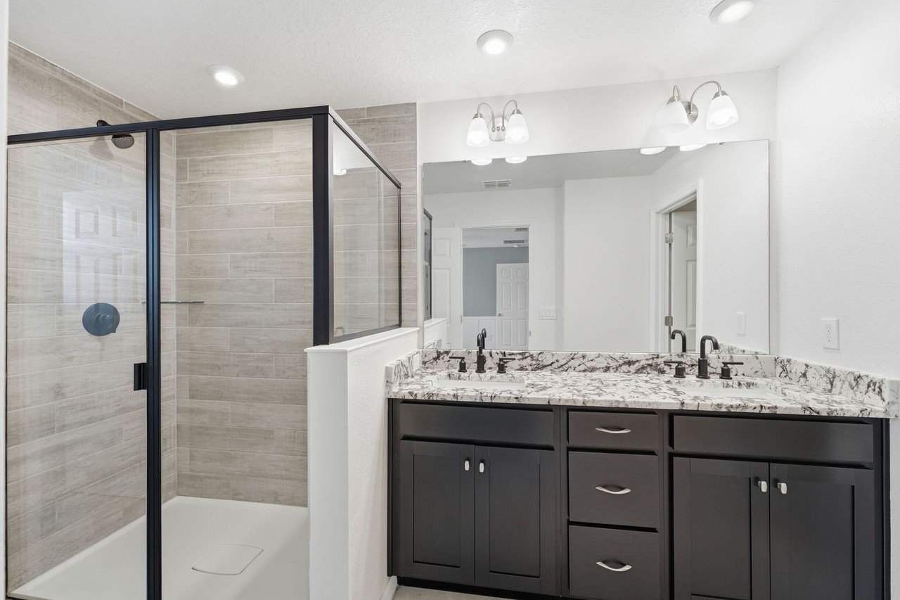 Primary bathroom with double vanity and granite counters