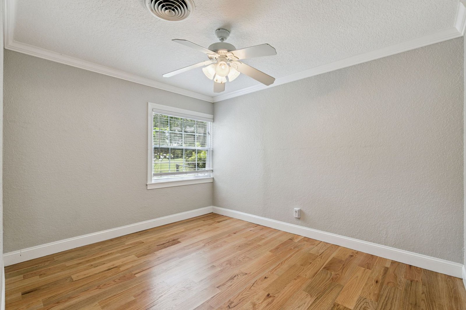 Second bedroom with hardwood floors and dual windows
