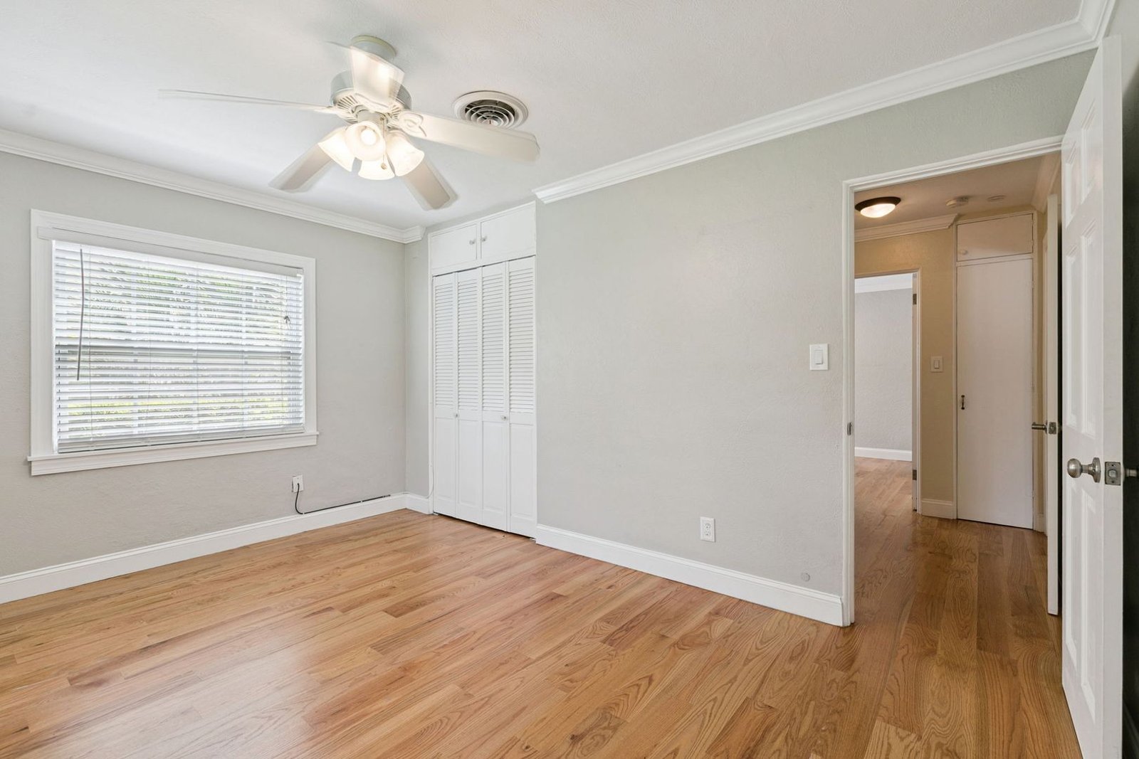 Bedroom with generous closet storage and hardwood floors