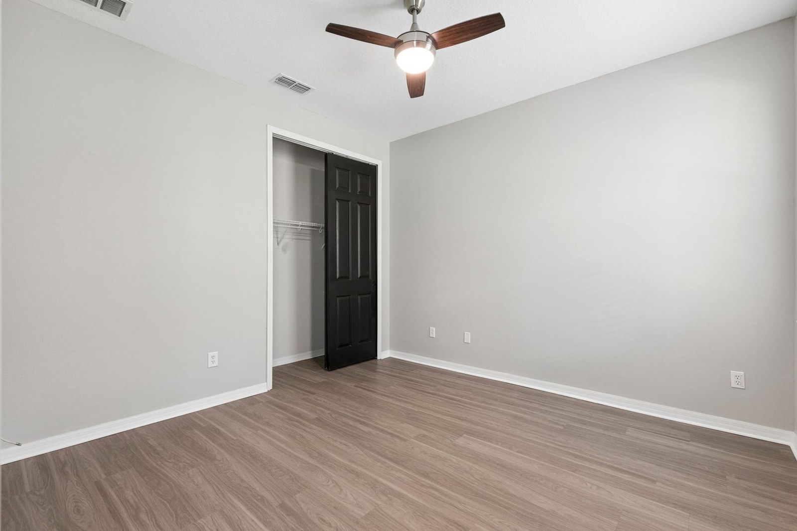 Third bedroom with wood-look flooring and closet