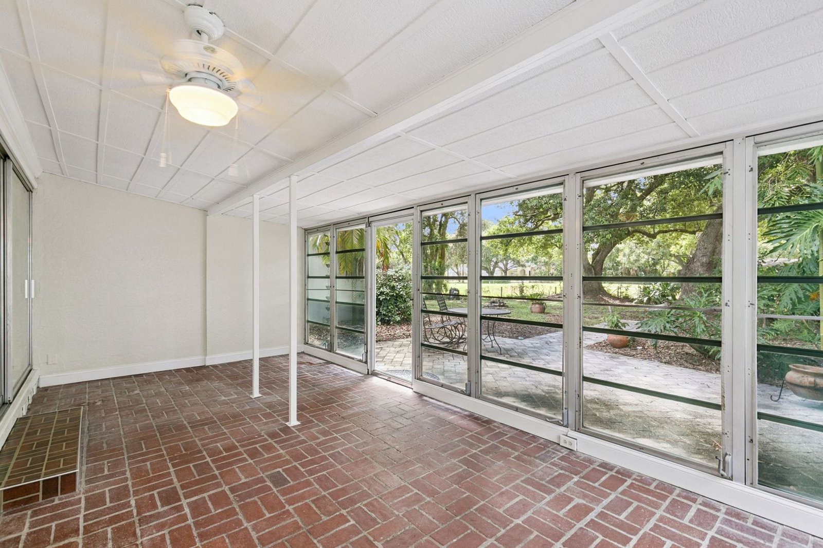 Air-conditioned Florida room with wall-to-wall windows overlooking the backyard