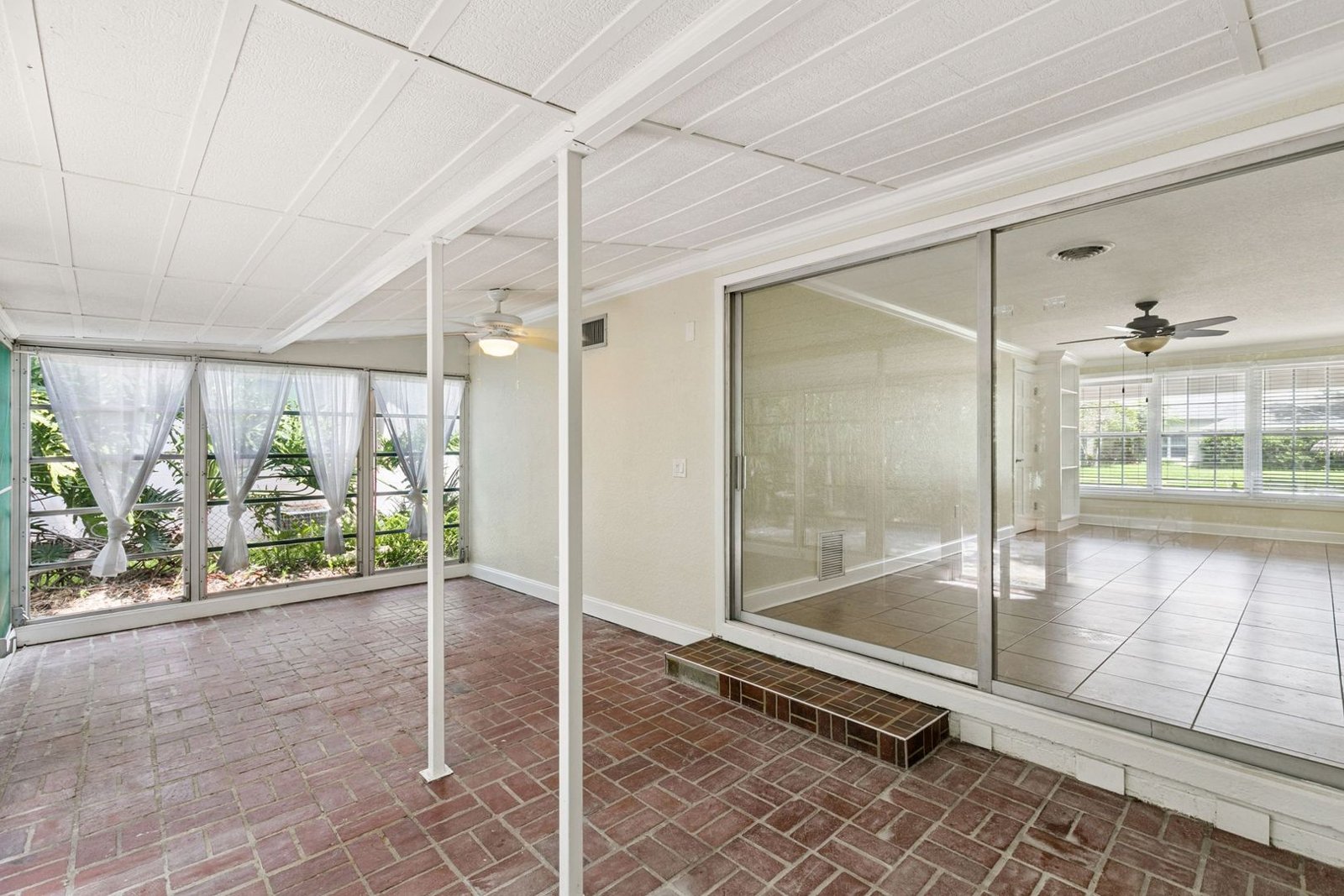 Florida room with sliding glass doors to the flex room and views of mature landscaping