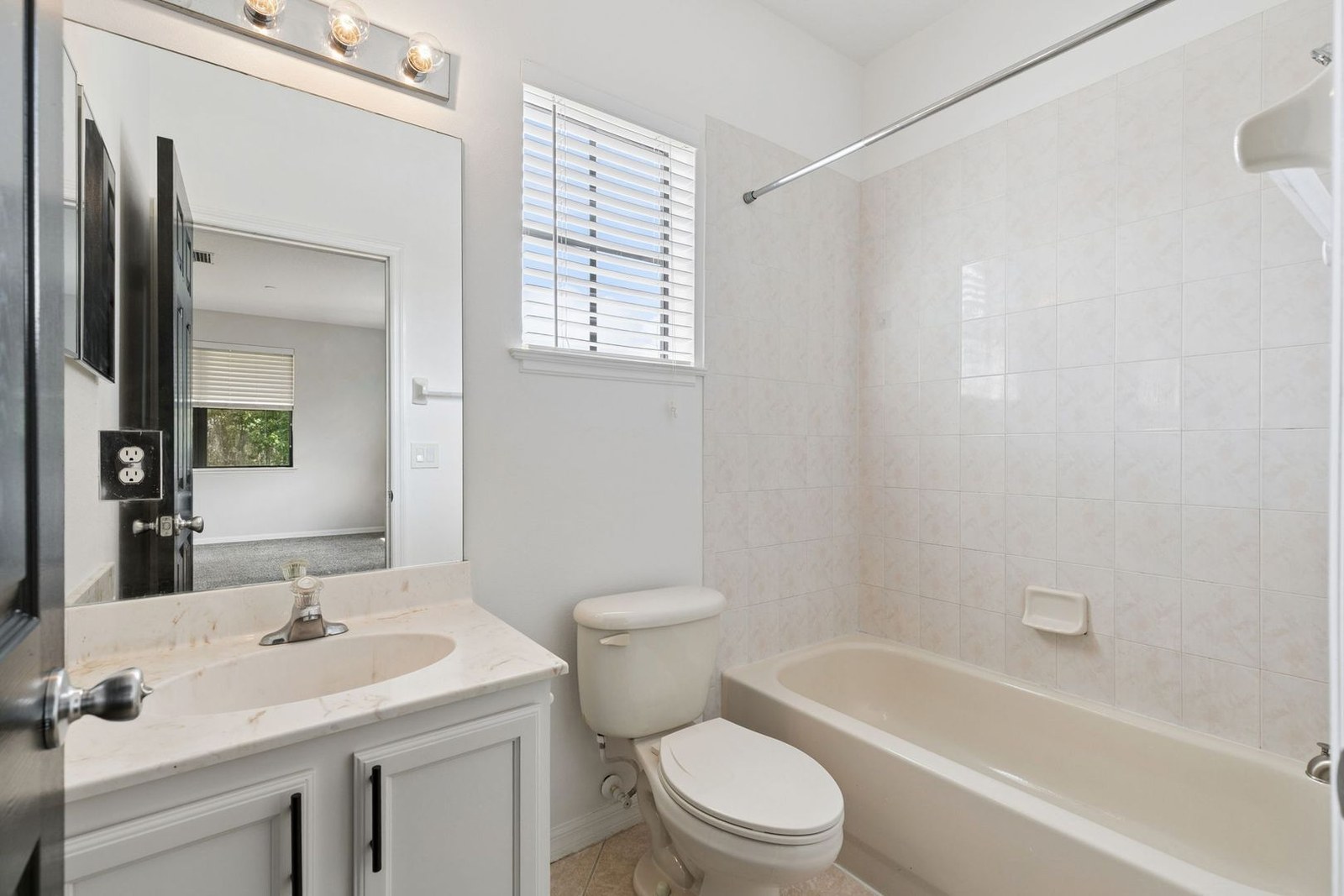Full bath with tub-shower combo shared by two bedrooms
