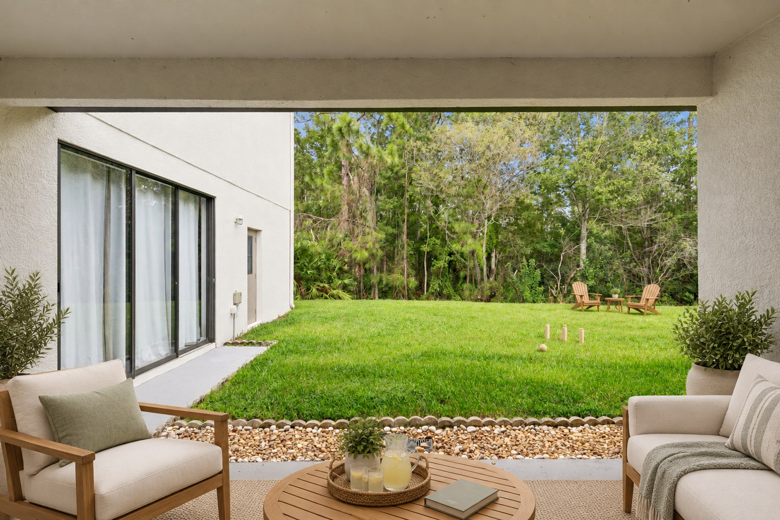 Virtually staged backyard with Adirondack chairs and the covered lanai at 10249 Park Row Ct