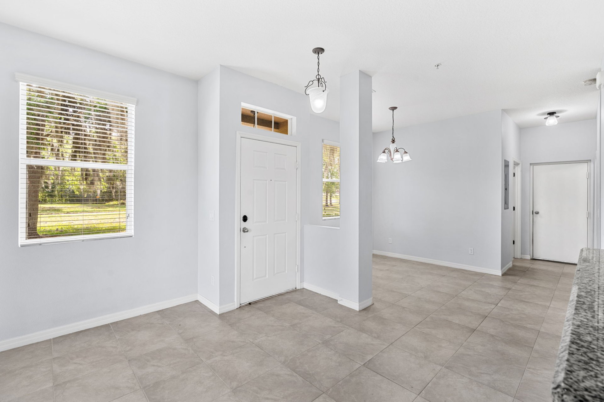 Entry foyer with tile floors and chandelier