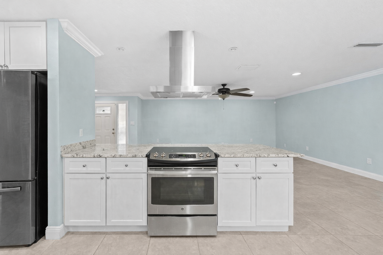 Kitchen with center cooktop and open view into living area