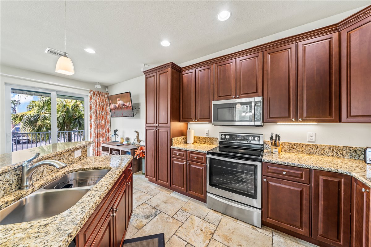 Full kitchen with warm wood cabinetry and stainless appliances