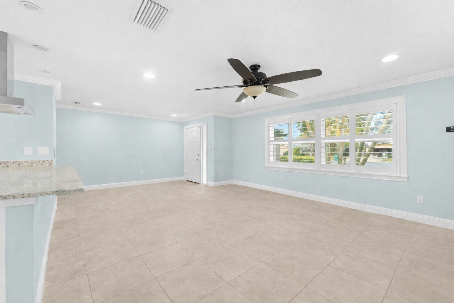 Living area with plantation shutters and tropical views