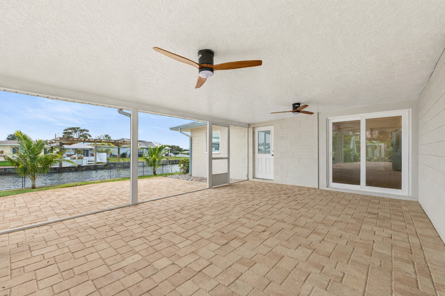 Screened patio with canal views and paver flooring