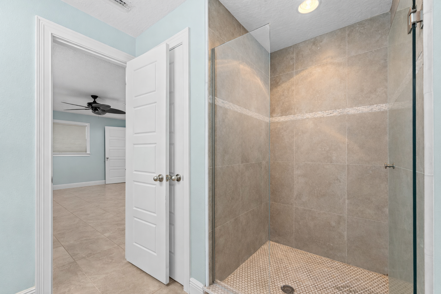 Walk-in tiled shower in updated bathroom