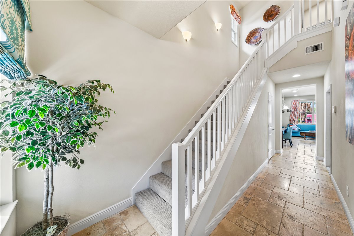 Two-story entryway with travertine floors and staircase