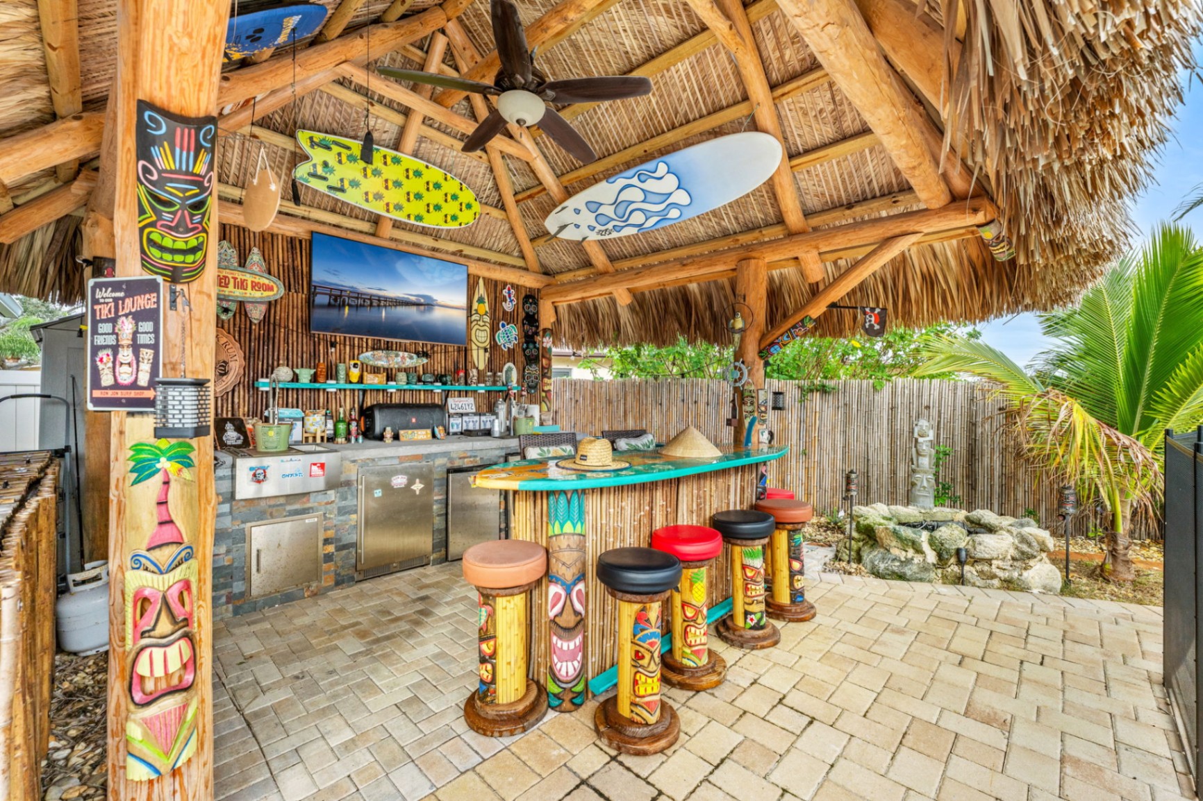 Full tiki bar with outdoor kitchen and colorful seating